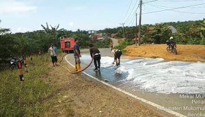 Personil Polsek Resort Penarik Bersihkan Tumpahan Solar di Jalan Raya Kecamtan Penarik