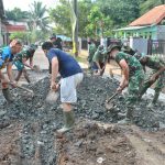 Personel TMMD dan warga gotong royong angkut pasir
