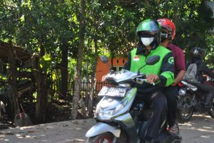 Pengojek Online Melintas Di Jalan Baru Dengan Santai